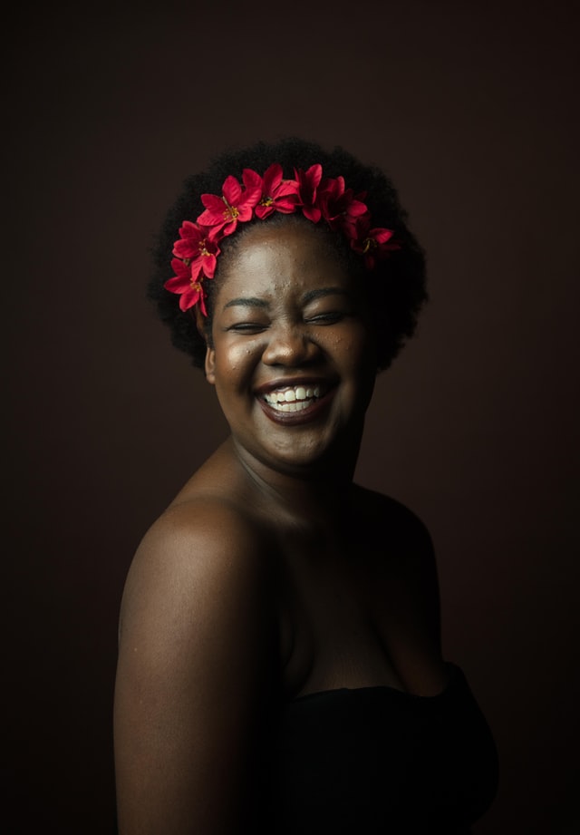 Nia Lesedi portrait. She is smiling and wearing a red flower crown.